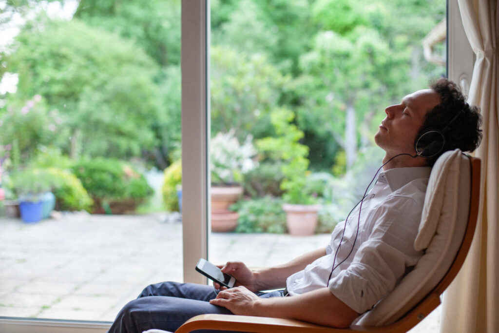 Person liegt entspannt auf Sessel – Nervensystem beruhigen und Stress reduzieren